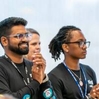 Two event attendees looking at stage and clapping